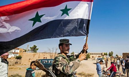 Soldado ondea bandera de Siria