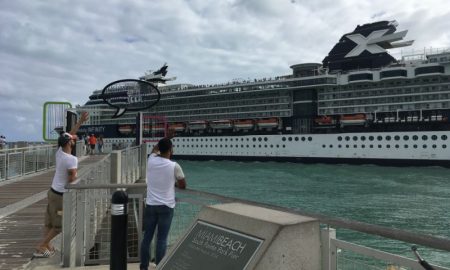 Dos personas saludan hacia un crucero