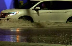 Sequía en Alabama disminuye tras intensas lluvias recientes Camioneta blanca atravesando una calle completamente inundada durante una tormenta.