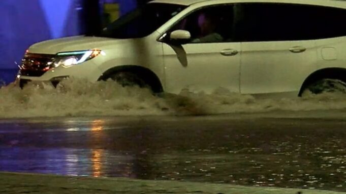 Sequía en Alabama disminuye tras intensas lluvias recientes Camioneta blanca atravesando una calle completamente inundada durante una tormenta.