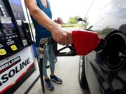 Gasolina de Costco alcanza volúmenes récord por precios Una persona utiliza una manguera con boquilla roja para cargar gasolina de Costco Kirkland Signature en su vehículo.