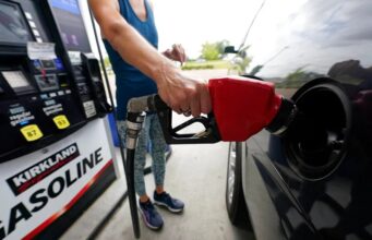 Gasolina de Costco alcanza volúmenes récord por precios Una persona utiliza una manguera con boquilla roja para cargar gasolina de Costco Kirkland Signature en su vehículo.