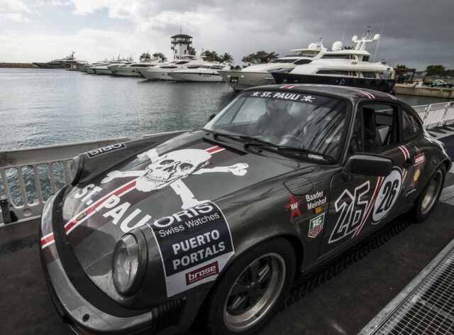 Muere un copiloto y el piloto herido muy grave en el Rallye de la Cerámica en Castellón Un coche clásico Porsche de rally gris con el logo de St. Pauli estacionado en un muelle náutico junto a yates.