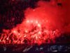 Liga de Campeones: Festejos del PSG dejan tres muertos Aficionados de fútbol encienden bengalas rojas en las tribunas para celebrar un triunfo deportivo.