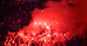 Liga de Campeones: Festejos del PSG dejan tres muertos Aficionados de fútbol encienden bengalas rojas en las tribunas para celebrar un triunfo deportivo.