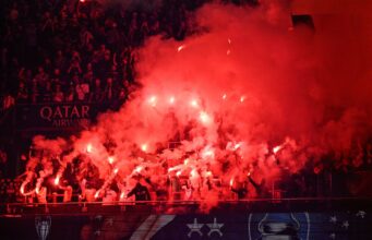 Liga de Campeones: Festejos del PSG dejan tres muertos Aficionados de fútbol encienden bengalas rojas en las tribunas para celebrar un triunfo deportivo.
