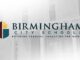 Empleo en Birmingham City Schools ofrece bonos de 1,000 dólares Logotipo de Birmingham City Schools con fondo difuminado del edificio de la junta de educación en Alabama.