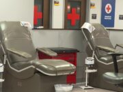 Donación de sangre en Alabama bajo alerta por escasez Sillones vacíos de color gris en una sala de donación de la Cruz Roja Americana con logotipos de cruces rojas al fondo.