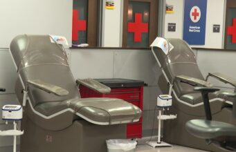 Donación de sangre en Alabama bajo alerta por escasez Sillones vacíos de color gris en una sala de donación de la Cruz Roja Americana con logotipos de cruces rojas al fondo.