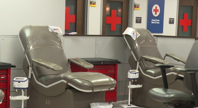 Donación de sangre en Alabama bajo alerta por escasez Sillones vacíos de color gris en una sala de donación de la Cruz Roja Americana con logotipos de cruces rojas al fondo.