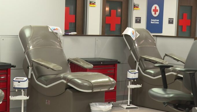Donación de sangre en Alabama bajo alerta por escasez Sillones vacíos de color gris en una sala de donación de la Cruz Roja Americana con logotipos de cruces rojas al fondo.