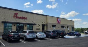 Chick-fil-A en Alabama recauda fondos por ex empleado ahogado Fachada exterior de un restaurante Chick-fil-A en Alabama con vehículos estacionados frente al establecimiento en un día despejado.