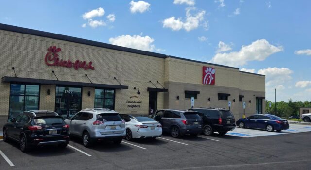 Chick-fil-A en Alabama recauda fondos por ex empleado ahogado Fachada exterior de un restaurante Chick-fil-A en Alabama con vehículos estacionados frente al establecimiento en un día despejado.
