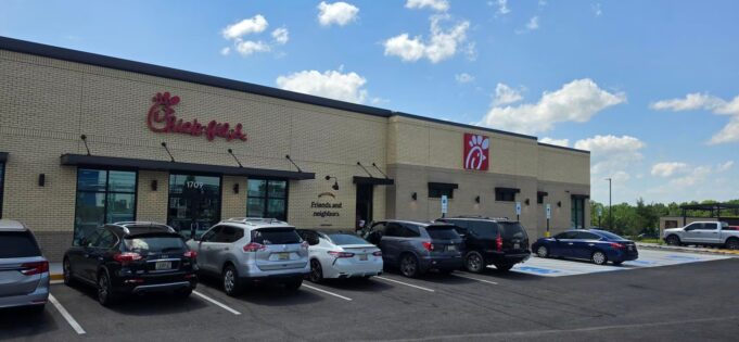 Chick-fil-A en Alabama recauda fondos por ex empleado ahogado Fachada exterior de un restaurante Chick-fil-A en Alabama con vehículos estacionados frente al establecimiento en un día despejado.