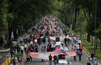 CNTE marcha hacia el Estadio Azteca y amenaza el Mundial 2026 Manifestación masiva de maestros de la CNTE sosteniendo una lona de huelga nacional en una avenida de México.