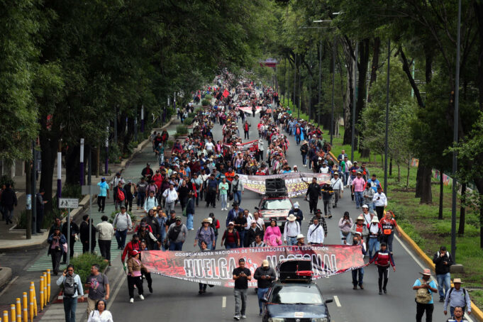 CNTE marcha hacia el Estadio Azteca y amenaza el Mundial 2026 Manifestación masiva de maestros de la CNTE sosteniendo una lona de huelga nacional en una avenida de México.