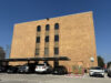 Cortes de inmigración aplican polémicas audiencias masivas Edificio de ladrillo marrón de la corte de inmigración en San Antonio con estacionamiento frontal de automóviles.