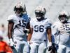 Arresto en Alabama: Da’Shawn Womack enfrenta cargos penales Tres jugadores de fútbol americano de Auburn con uniforme blanco y cascos protectores durante una práctica en Alabama.
