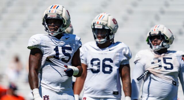 Arresto en Alabama: Da’Shawn Womack enfrenta cargos penales Tres jugadores de fútbol americano de Auburn con uniforme blanco y cascos protectores durante una práctica en Alabama.