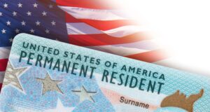 Residencia permanente en EE. UU.: DHS aclara nuevas reglas Tarjeta de residencia permanente de Estados Unidos frente a una bandera estadounidense en un trámite del DHS.