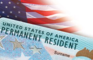 Residencia permanente en EE. UU.: DHS aclara nuevas reglas Tarjeta de residencia permanente de Estados Unidos frente a una bandera estadounidense en un trámite del DHS.