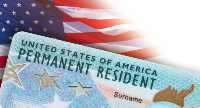 Residencia permanente en EE. UU.: DHS aclara nuevas reglas Tarjeta de residencia permanente de Estados Unidos frente a una bandera estadounidense en un trámite del DHS.