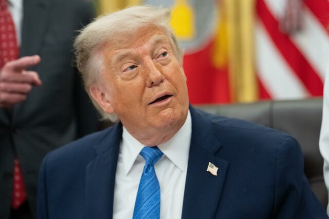 Donald Trump con traje azul y corbata azul gesticulando durante una conferencia de prensa oficial en la Casa Blanca.