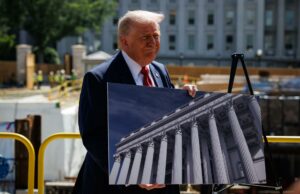Donald Trump respalda a Abelardo de la Espriella en Colombia Donald Trump sonríe sosteniendo una fotografía de un edificio con columnas clásicas durante un evento de prensa exterior.