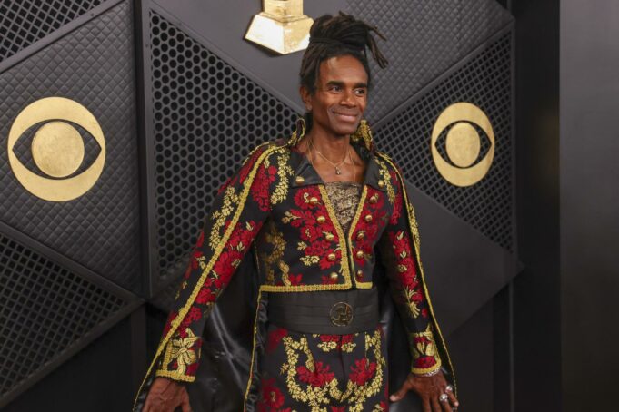 Milli Vanilli: Fab Morvan cancela show con Donald Trump El cantante Fab Morvan posa sonriente en una alfombra roja con un traje negro y rojo bordado.