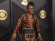 Milli Vanilli: Fab Morvan cancela show con Donald Trump El cantante Fab Morvan posa sonriente en una alfombra roja con un traje negro y rojo bordado.