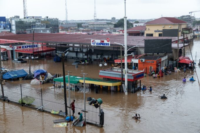 Inundaciones en Ghana dejan doce muertos y graves destrozos Calles inundadas en la terminal 2M Express de Acra, Ghana, con personas caminando con el agua a la cintura.