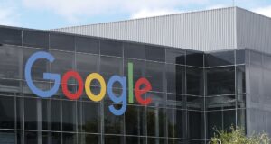 Inteligencia artificial impulsa a Alphabet a vender acciones por $80.000 millones Fachada acristalada de un edificio de Google que refleja el cielo en su sede corporativa de Alphabet.