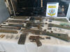 Histórica incautación de armas y marihuana en Paraguay Piezas y cañones de fusil desmontados sobre un mantel blanco junto al escudo impreso de la Digemabel de Paraguay.