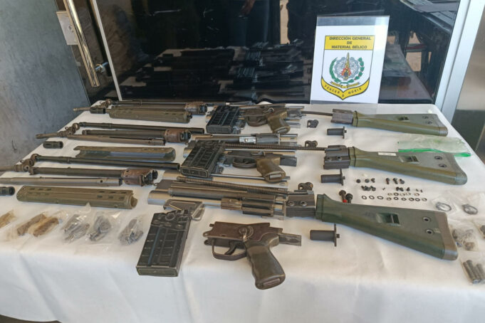 Histórica incautación de armas y marihuana en Paraguay Piezas y cañones de fusil desmontados sobre un mantel blanco junto al escudo impreso de la Digemabel de Paraguay.