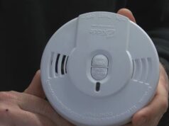 Detectores de humo gratis en Moody: cómo solicitarlos Manos de un bombero sosteniendo un detector de humo circular blanco de la marca Kidde para instalación gratuita en Moody.