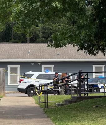 Investigan homicidio en Birmingham tras una discusión armada Patrullas policiales y cinta de seguridad amarilla frente a una vivienda gris durante investigación en Birmingham.