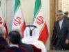 Acuerdo con EE.UU.: Irán frena la expectativa de Donald Trump Funcionario iraní camina en una sala de reuniones con banderas oficiales de Irán al fondo.