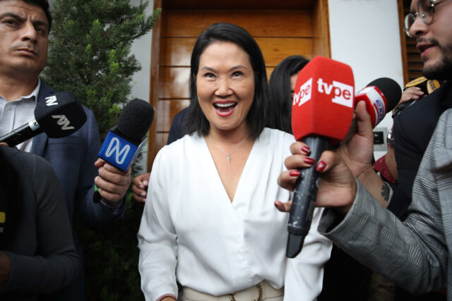 Keiko Fujimori sonríe rodeada de micrófonos de prensa de TV Perú y otros medios tras las elecciones en Perú.