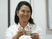 Keiko Fujimori gana la presidencia tras cómputo al 100% Keiko Fujimori sonríe mientras sostiene su documento de identidad tras confirmarse los resultados electorales en Perú.