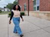 Maestra de DLI regresa a Escuelas de Birmingham Maestra de DLI Reiniela Ortiz camina frente al edificio de ladrillo rojo de una escuela en Alabama.