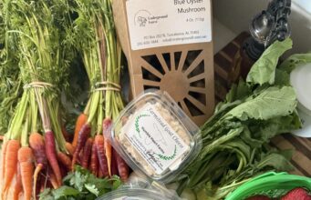 Mercado agrícola de Huntsville celebra éxito de su modelo digital Alimentos frescos del mercado de Huntsville que incluyen fresas, zanahorias, ensalada y cartón de huevos.