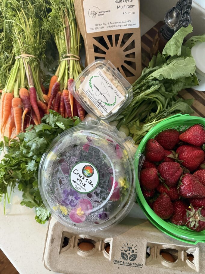 Mercado agrícola de Huntsville celebra éxito de su modelo digital Alimentos frescos del mercado de Huntsville que incluyen fresas, zanahorias, ensalada y cartón de huevos.