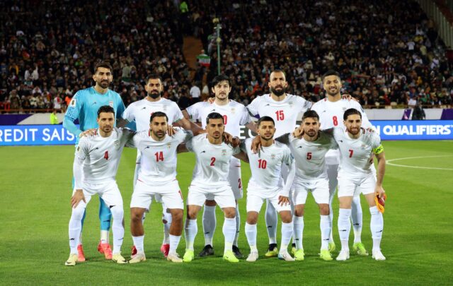 Once jugadores de la selección de fútbol de Irán posan formados en la cancha antes de un partido.