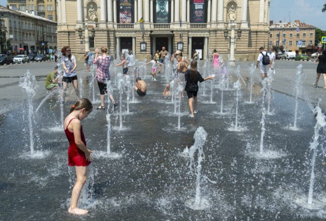 Niños y jóvenes refrescándose en una fuente pública en Ucrania durante una histórica ola de calor.