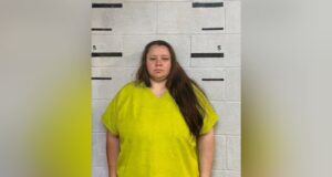 Caso condado de Bibb: Juez avala acuerdo de culpabilidad Retrato policial de Rebecca Brewer con uniforme amarillo brillante frente a una pared de bloques para ficha técnica.