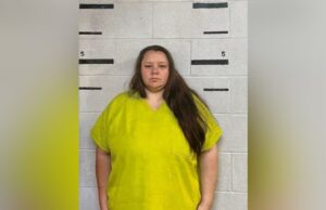 Caso condado de Bibb: Juez avala acuerdo de culpabilidad Retrato policial de Rebecca Brewer con uniforme amarillo brillante frente a una pared de bloques para ficha técnica.