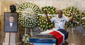 Muerte de Alex Bueno: El Teatro Nacional despide al cantante Capilla ardiente de Alex Bueno con su féretro cubierto por la bandera dominicana y arreglos florales en su honor.