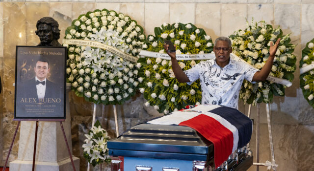 Muerte de Alex Bueno: El Teatro Nacional despide al cantante Capilla ardiente de Alex Bueno con su féretro cubierto por la bandera dominicana y arreglos florales en su honor.