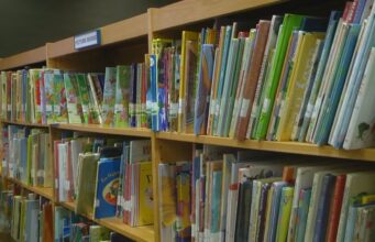 Resultados de la prueba ACAP de lectura en Alabama 2026 Estanterías de madera repletas de libros infantiles de colores en una biblioteca escolar de Alabama.
