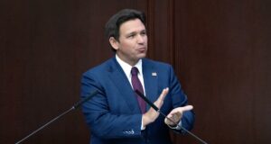 Reducción de impuestos inmobiliarios en Florida irá a voto El gobernador de Florida Ron DeSantis con traje azul en un podio hablando sobre la reducción de impuestos inmobiliarios.